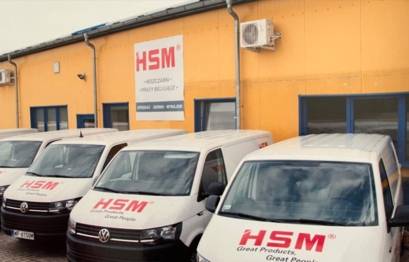 HSM Service Fahrtzeuge vor einem gelben Gebäude